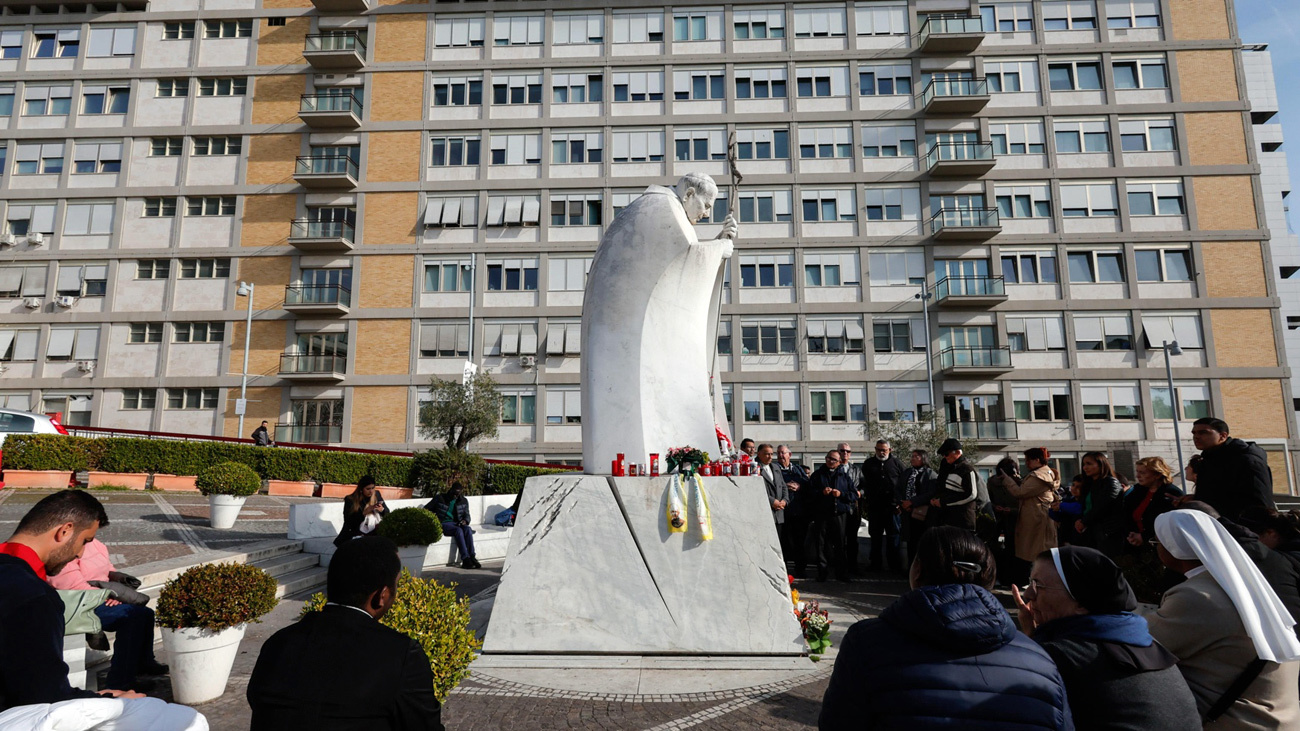 Fieles rezan junto a la estatua de Juan Pablo II y frente al hospital Gemelli de Roma, donde permanece ingresado el papa Francisco